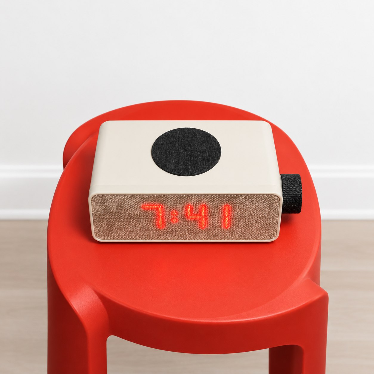Top-down view of the Aveira One's dock and speaker grille on a red side table